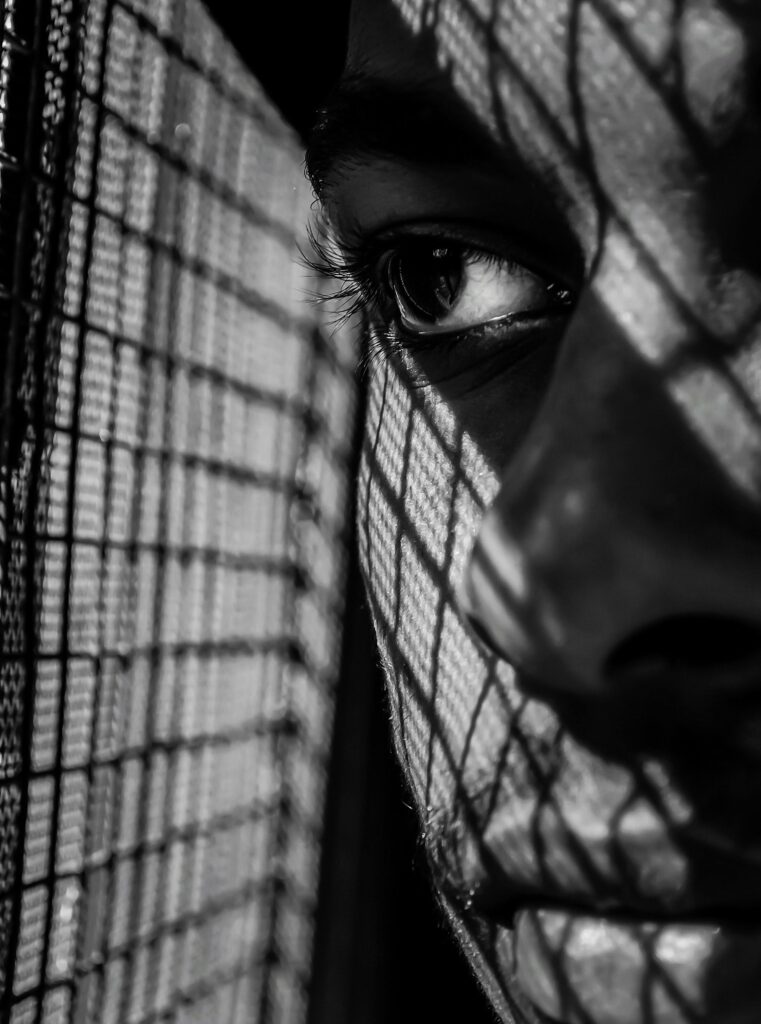 “Vrouw kijkt uit het raam en reflecteert op haar burn-out en de last van erfelijk familie trauma”
